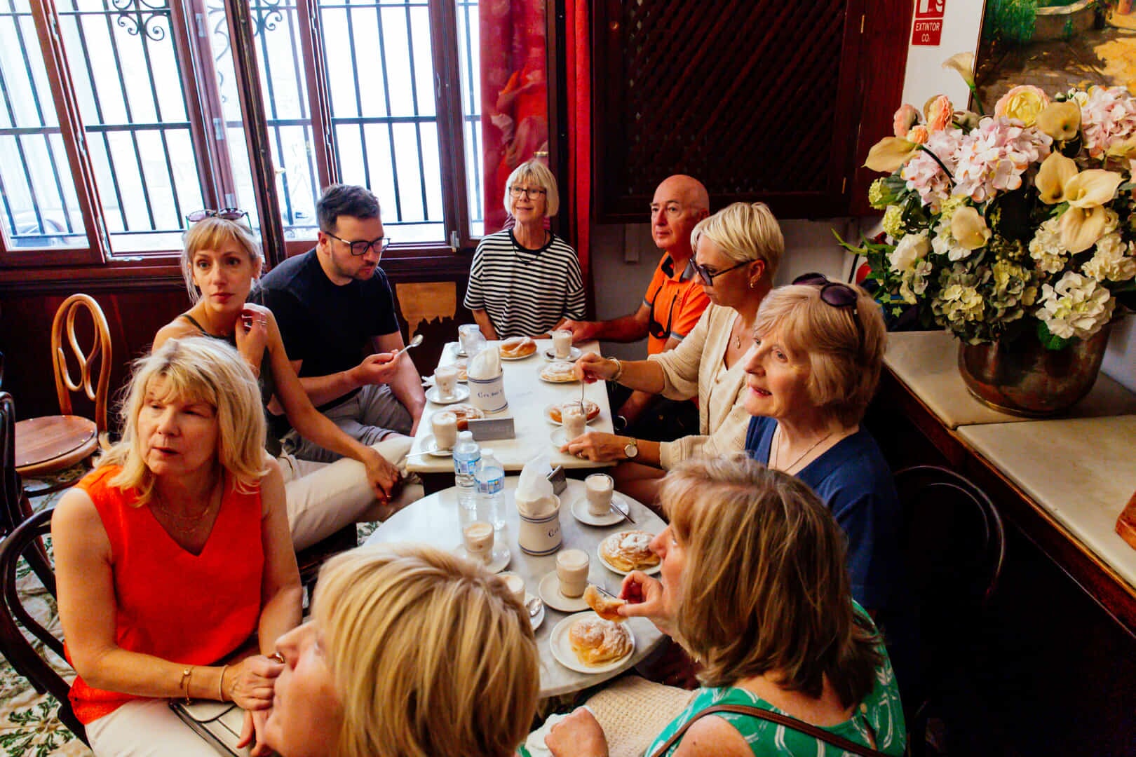 Group of people seated at a traditional Mallorcan restaurant enjoying coca and granizado during a Palma Food Tour
